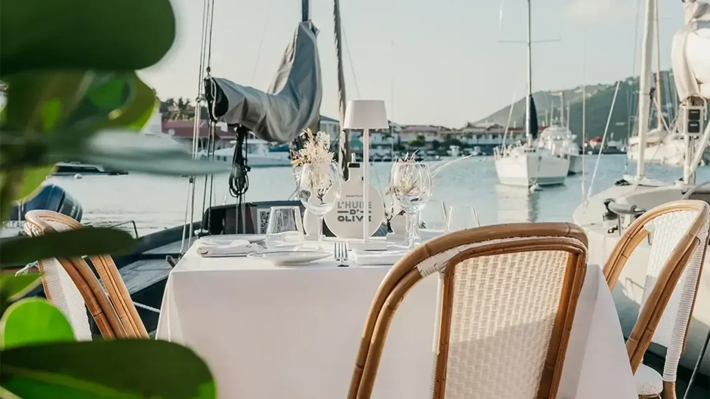 Bagatelle St. Barts waterfront dining, a beautifully set table with harbor views and sailboats.