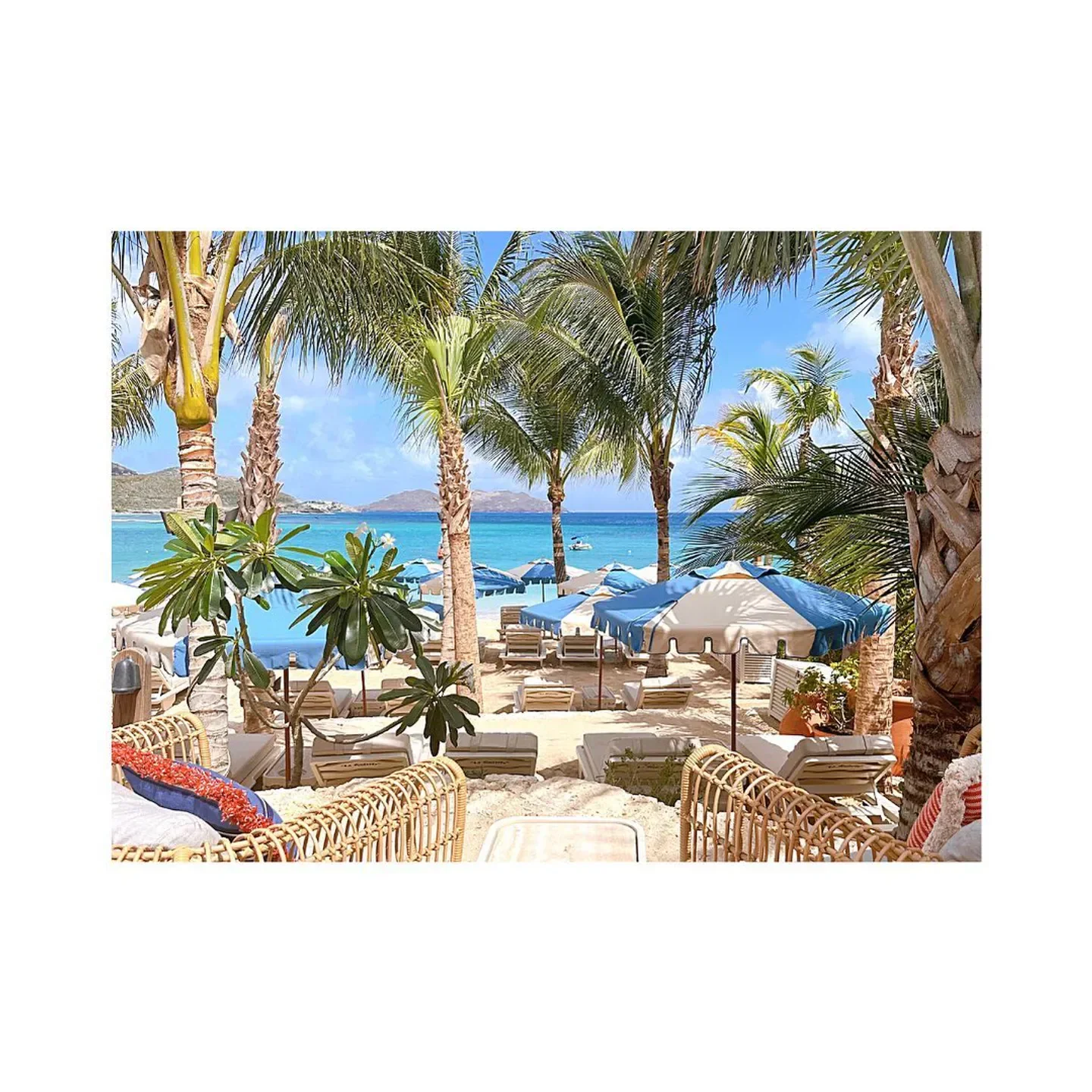 Beachfront view of La Guérite in St. Barts, with palm trees and ocean views.