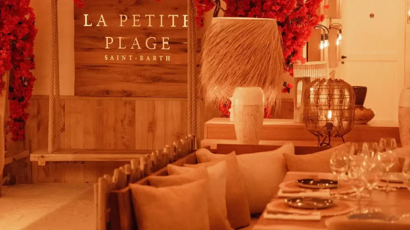 Interior of La Petite Plage restaurant in St. Barts with floral decor and swing.