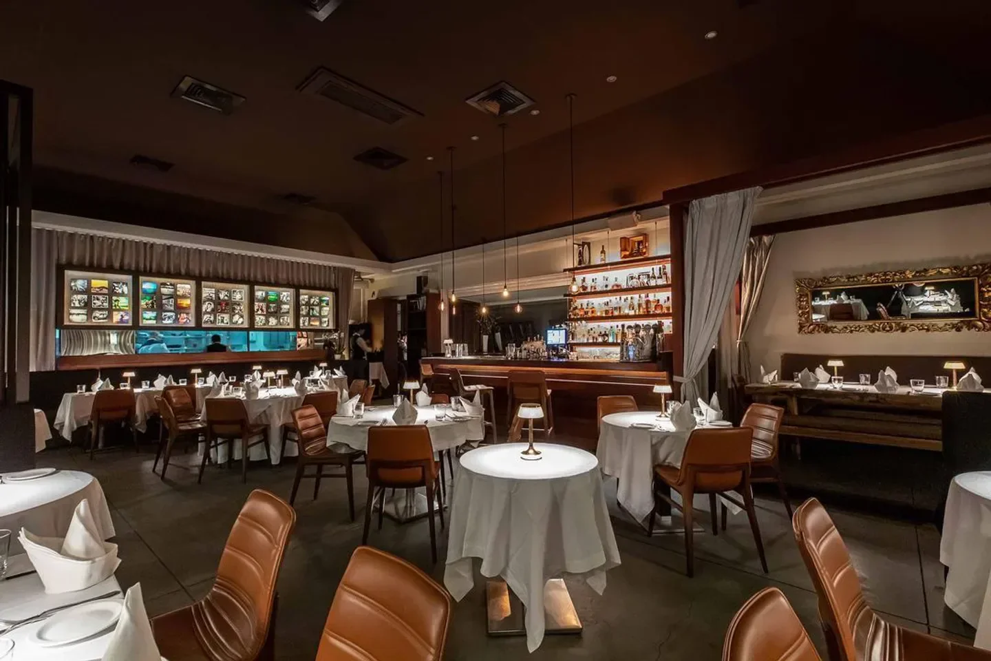 Interior of L'Isola restaurant in St. Barts, showcasing tables, bar, and elegant ambiance.