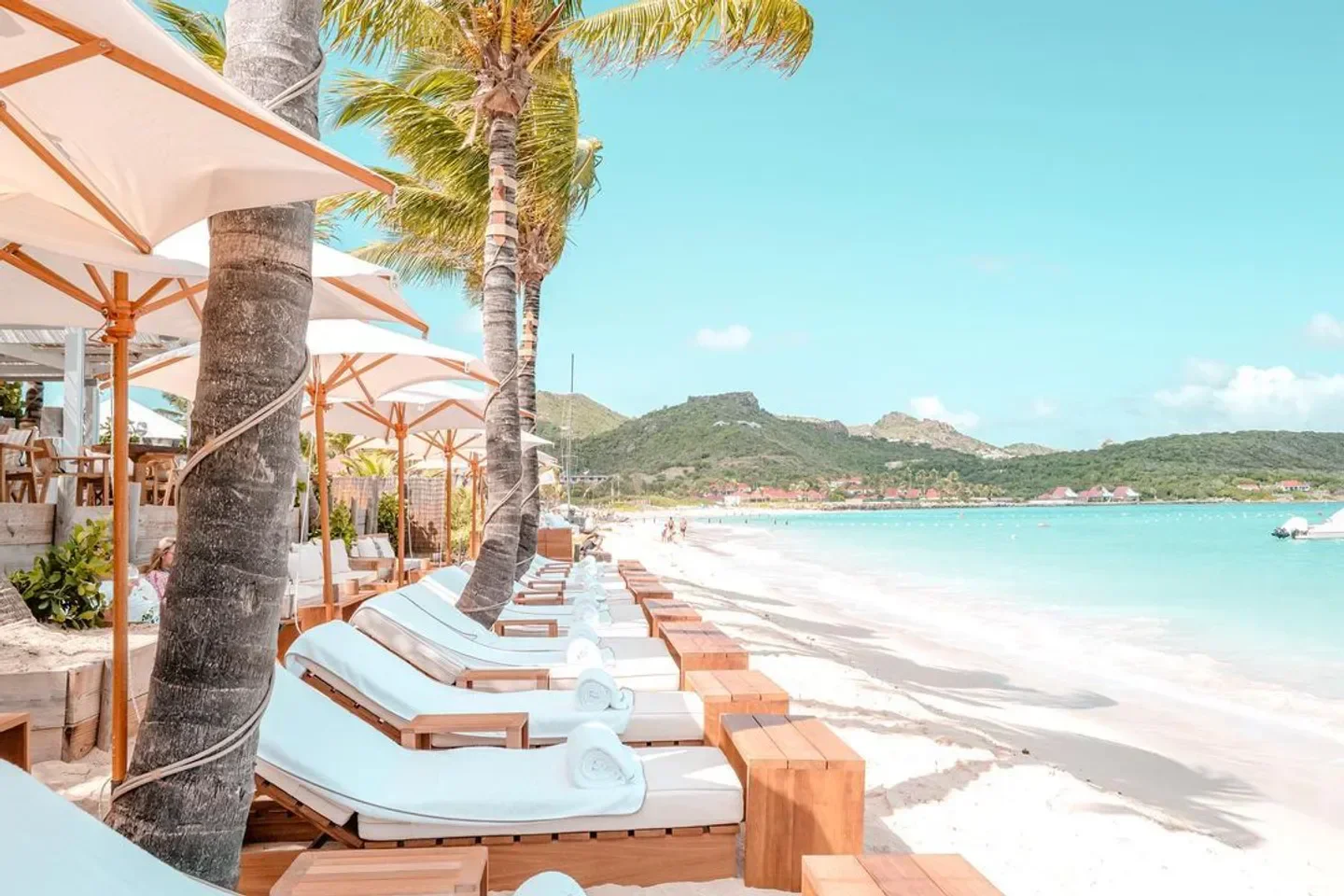 Beachfront view at Nao Beach, St. Barts, with lounge chairs and umbrellas along the sand