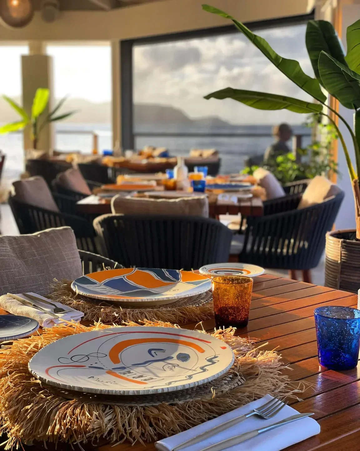 Rivyera restaurant in St. Barts with plates set, overlooking the ocean at sunset.