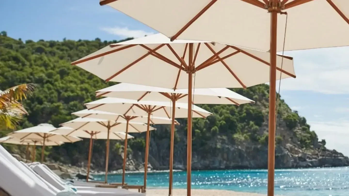 Shellona Beach in St. Barts with beach umbrellas over lounge chairs on the sand